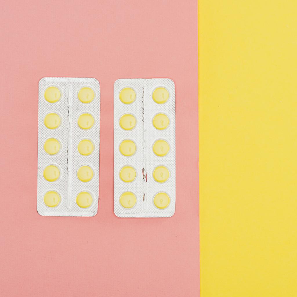 vista superior de las píldoras aisladas sobre fondo rosa y amarillo
 - Foto, imagen