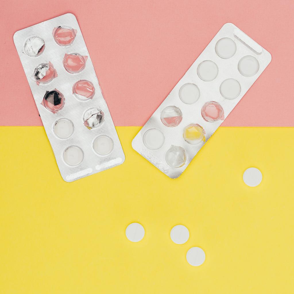 ylhäältä pillerit eristetty vaaleanpunainen ja keltainen tausta
 - Valokuva, kuva