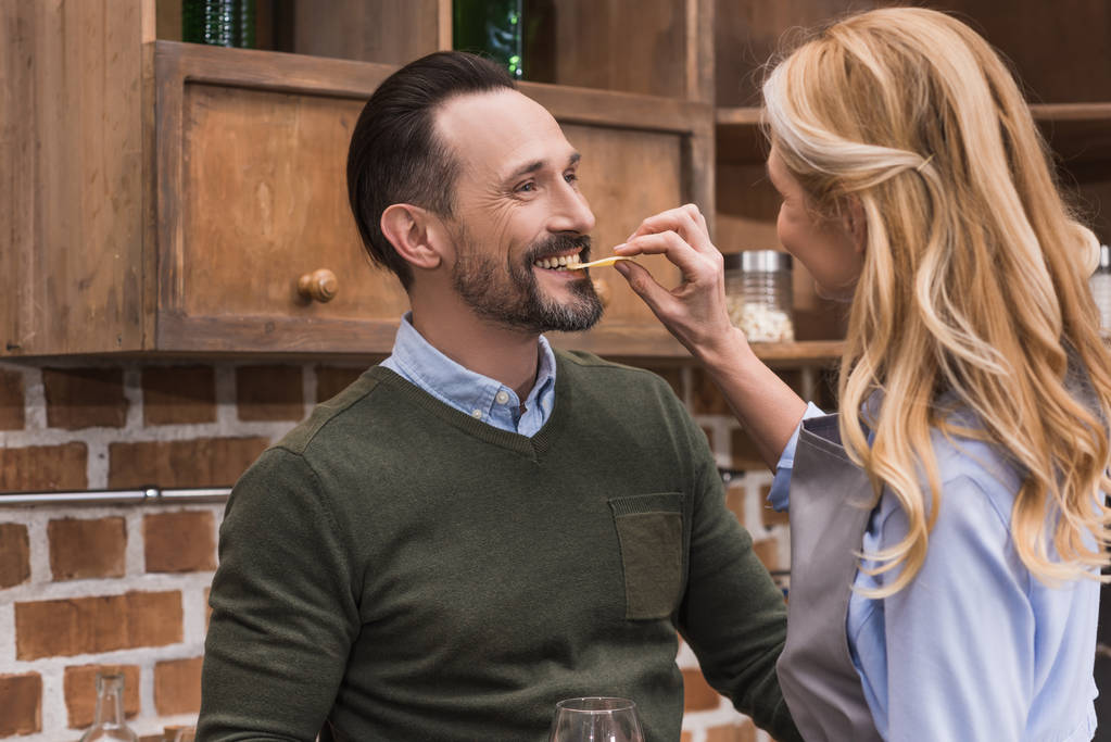 дружина дає чоловікові кусати шматочок сиру
 - Фото, зображення