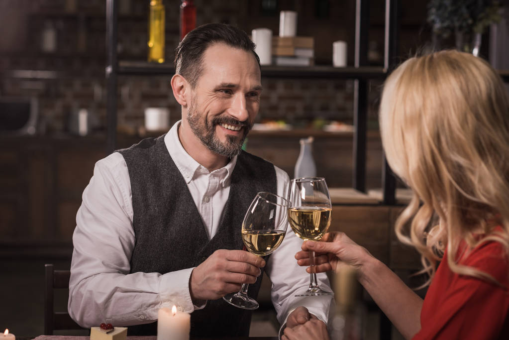 glückliches Paar klingelt beim Abendessen zu Hause mit einem Glas Wein - Foto, Bild