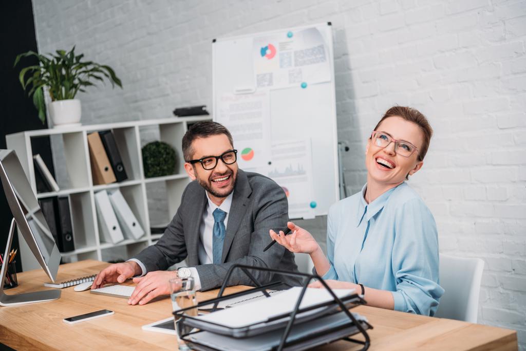 смеющиеся счастливые деловые партнеры в современном офисе
 - Фото, изображение