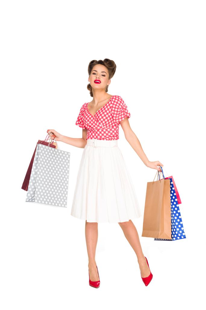 mujer joven en ropa de estilo retro con bolsas de compras aisladas en blanco
 - Foto, Imagen