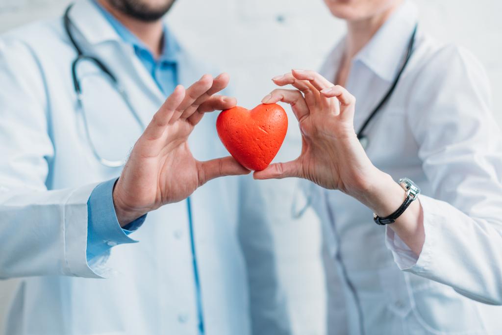 cropped shot of doctors holding toy heart together - Photo, Image