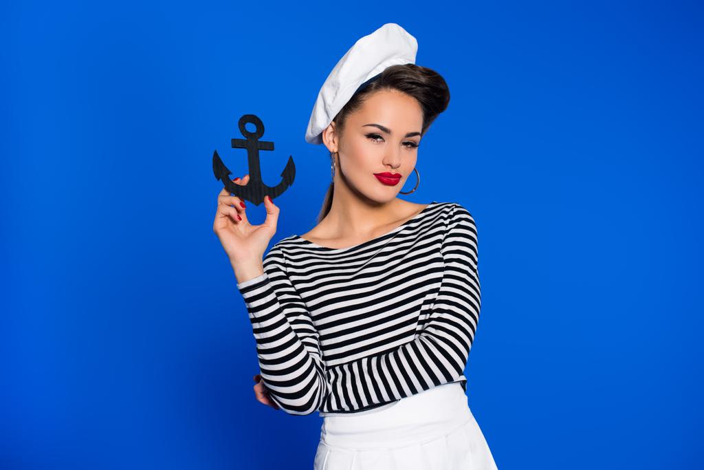 portrait of fashionable young woman in retro clothing with anchor in hand isolated on blue - Photo, Image