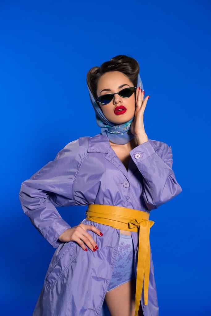 πορτρέτο του κομψή γυναίκα σε ρετρό ρούχα και τα γυαλιά ηλίου που απομονώνονται σε μπλε - Φωτογραφία, εικόνα