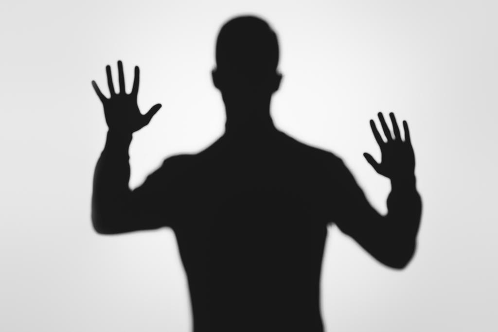 μυστηριώδη θολή σκιά του ατόμου που θέτει τα χέρια σε γκρι - Φωτογραφία, εικόνα