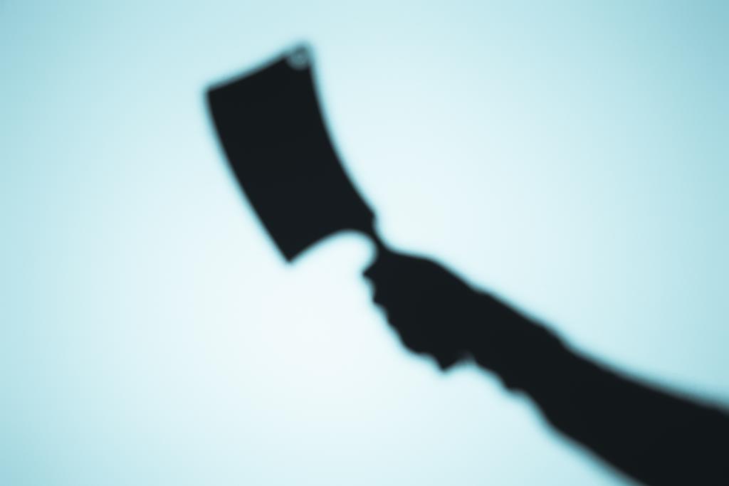 espeluznante sombra borrosa de la persona sosteniendo cuchillo de carne en azul
 - Foto, Imagen
