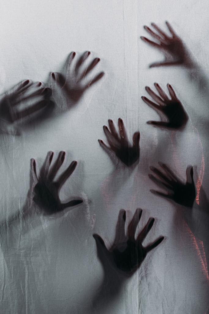 расплывчатые страшные силуэты человеческих рук, касающихся матового стекла
 - Фото, изображение