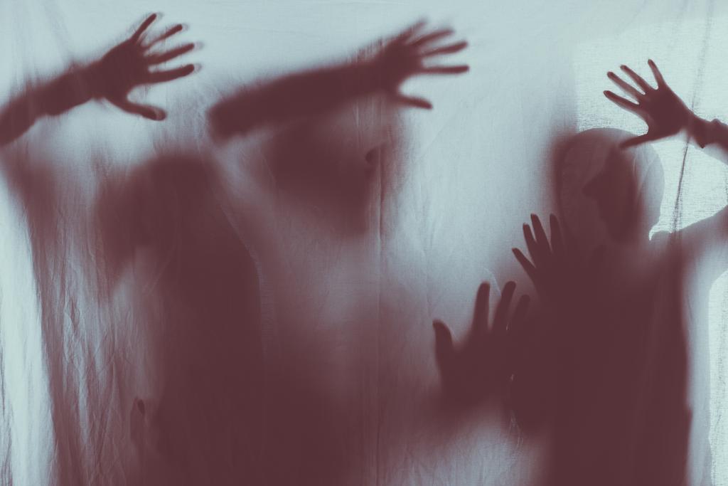 siluetas de miedo borrosa de personas que tocan vidrio esmerilado con las manos
 - Foto, imagen