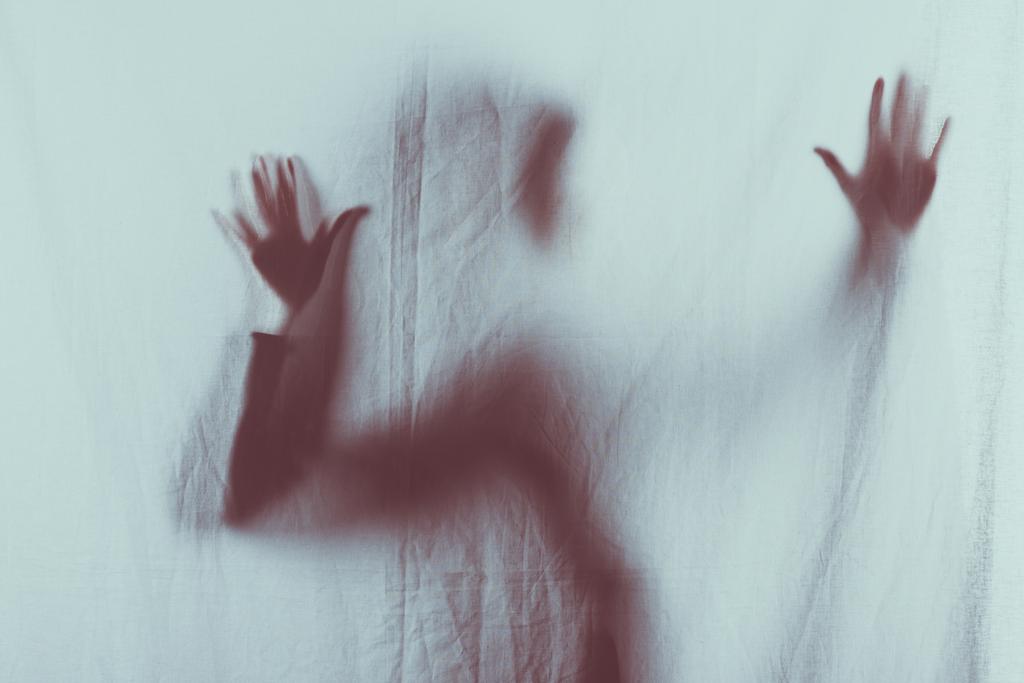 silueta borrosa miedo de la persona tocando el velo con las manos
 - Foto, Imagen