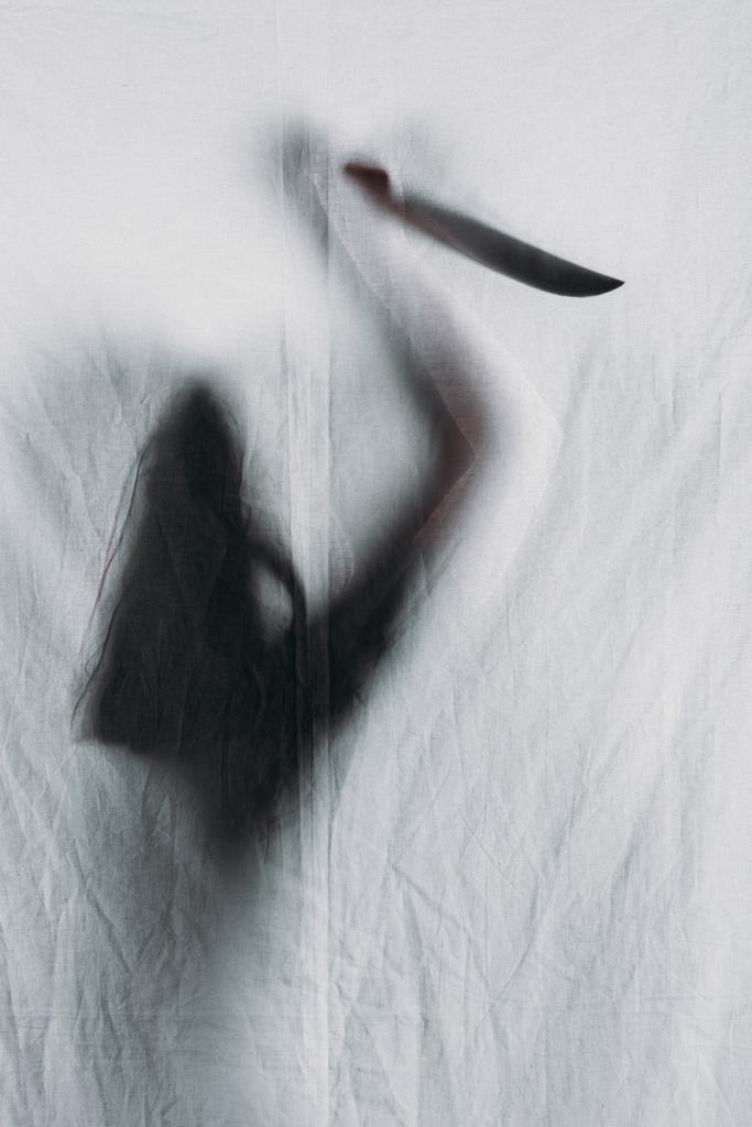 τρομακτικό θολή σιλουέτα του προσώπου που κρατάει μαχαίρι πίσω από το πέπλο - Φωτογραφία, εικόνα