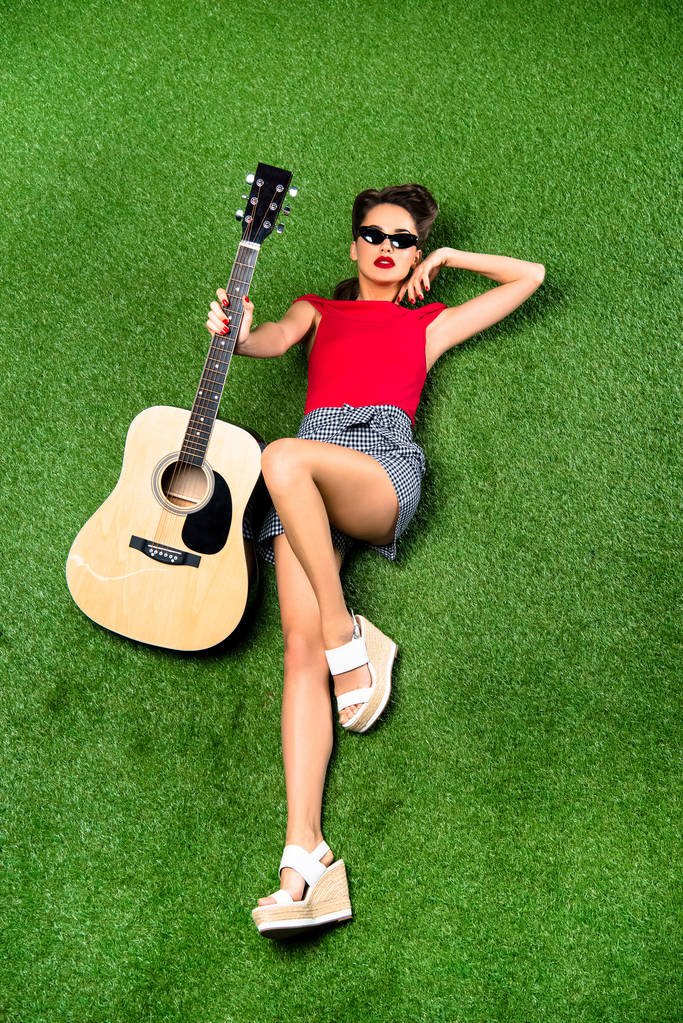 vista aérea da mulher bonita com guitarra descansando no gramado verde
 - Foto, Imagem