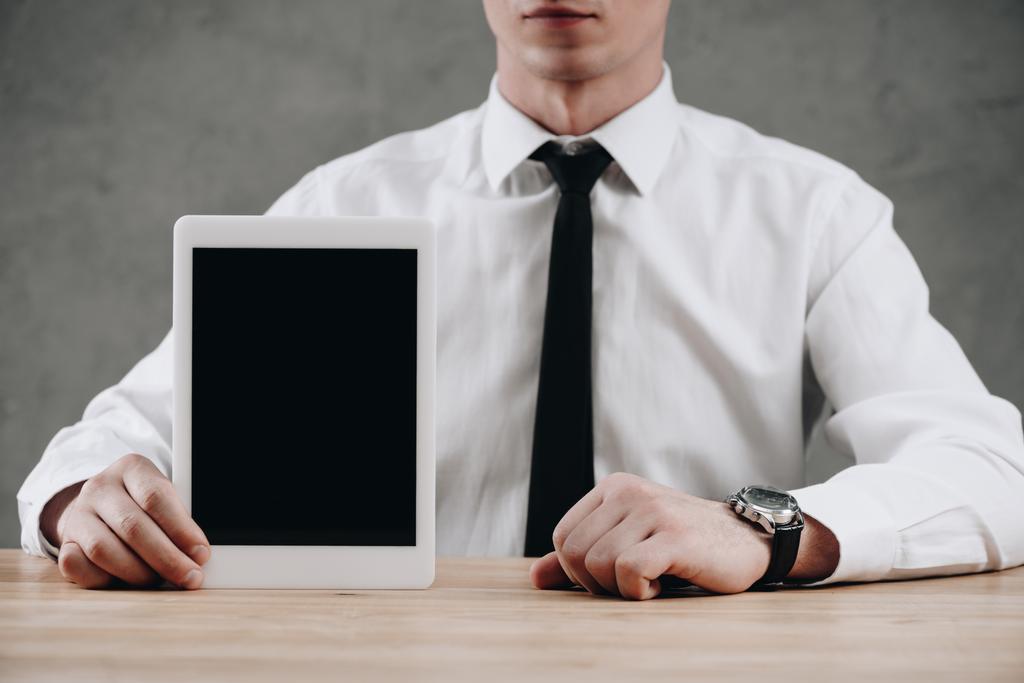 mid sectie van zakenman holding digitale tablet met leeg scherm - Foto, afbeelding