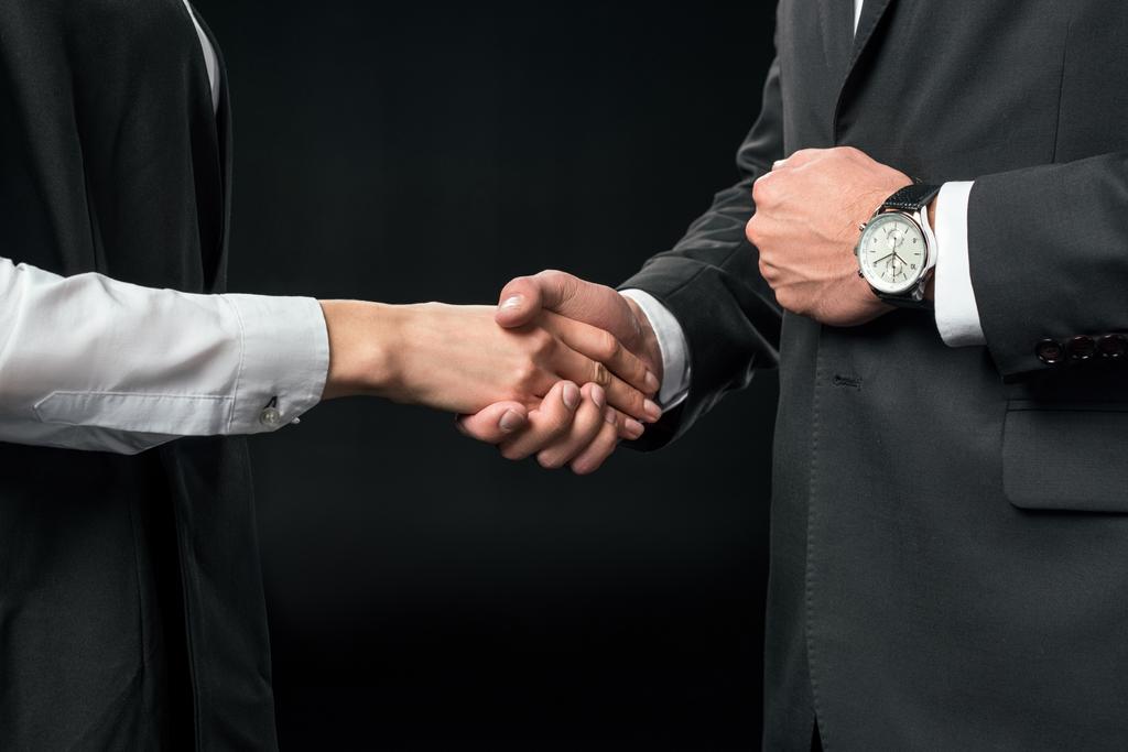 cropped view of businesspeople shaking hands, isolated on black - Photo, Image