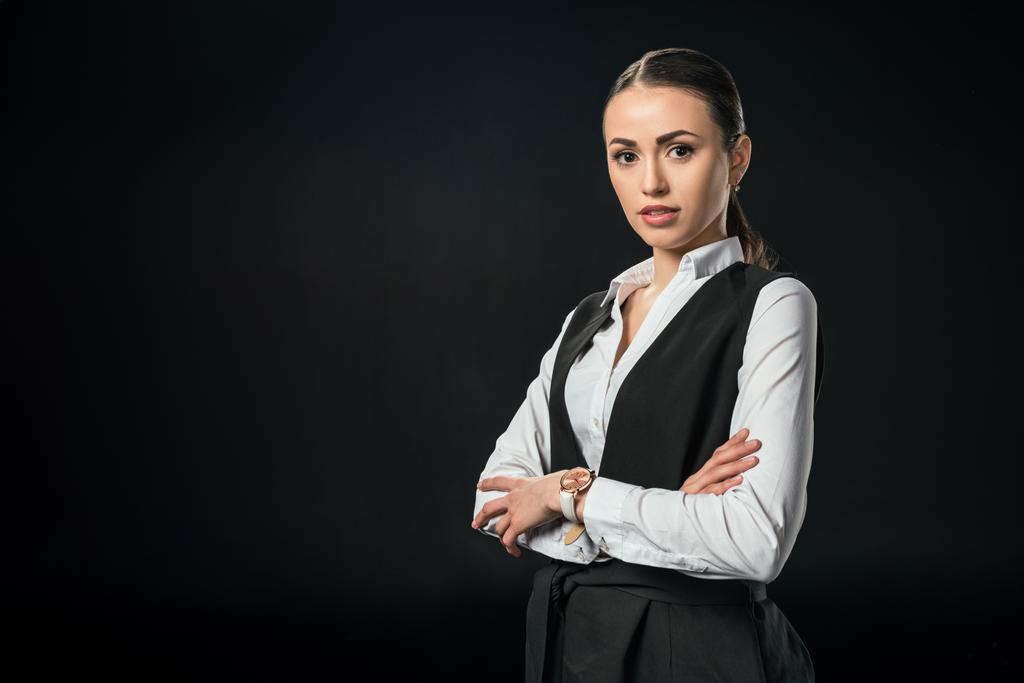 young beautiful businesswoman with crossed arms, isolated on black - Photo, Image