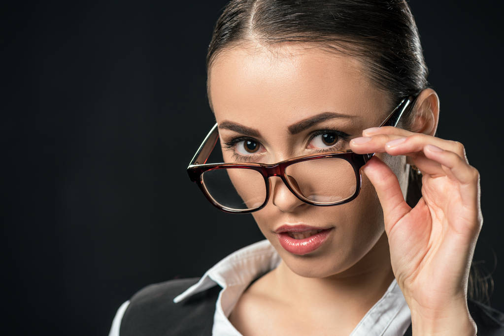 portret piękna bizneswoman w okularach, patrząc na kamery, na czarnym tle - Zdjęcie, obraz