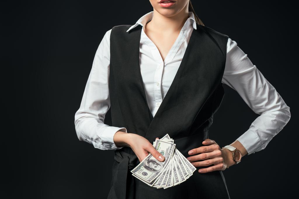 vista ritagliata di donna d'affari in possesso di banconote in dollari, isolato su nero
 - Foto, immagini