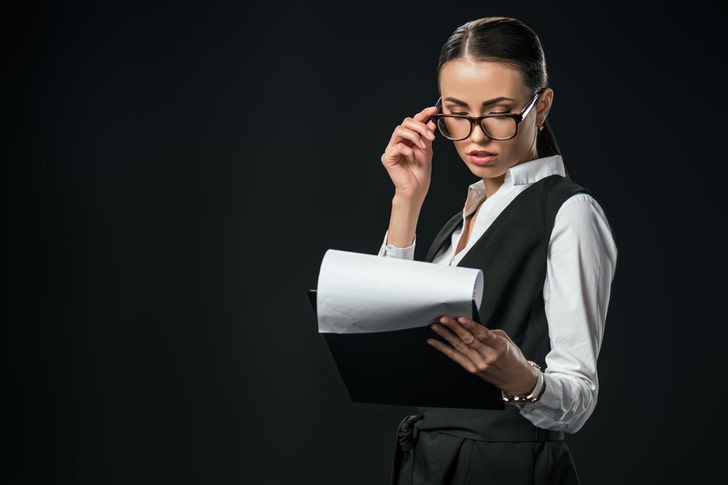 confiada empresaria sosteniendo documentos en el portapapeles, aislado en negro
 - Foto, Imagen