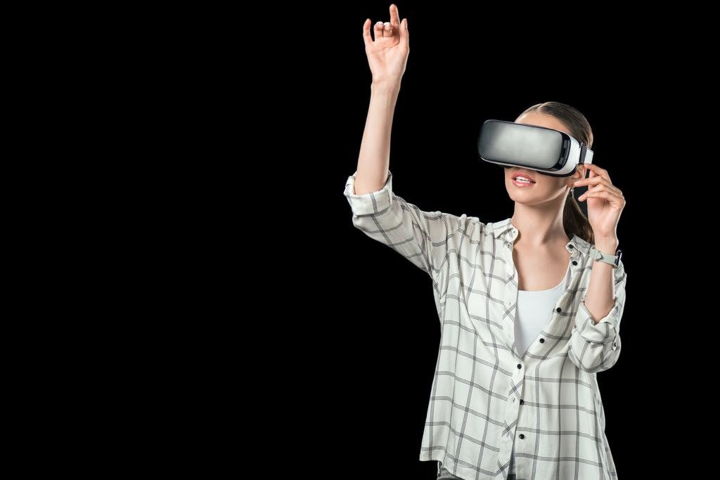 girl gesturing and using virtual reality headset, isolated on black - Photo, Image