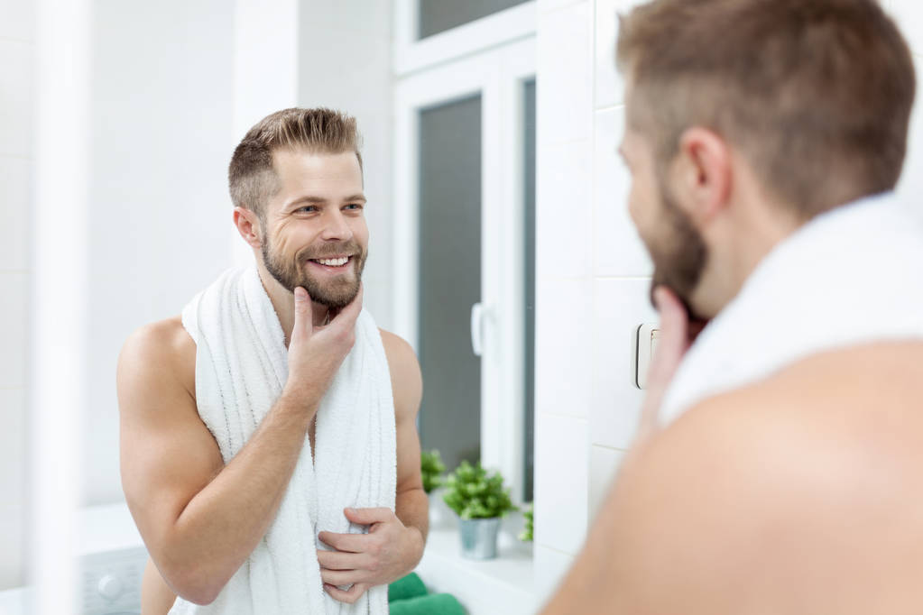 Ochtend hygiëne, Man in de badkamer in spiegel kijken - Foto, afbeelding