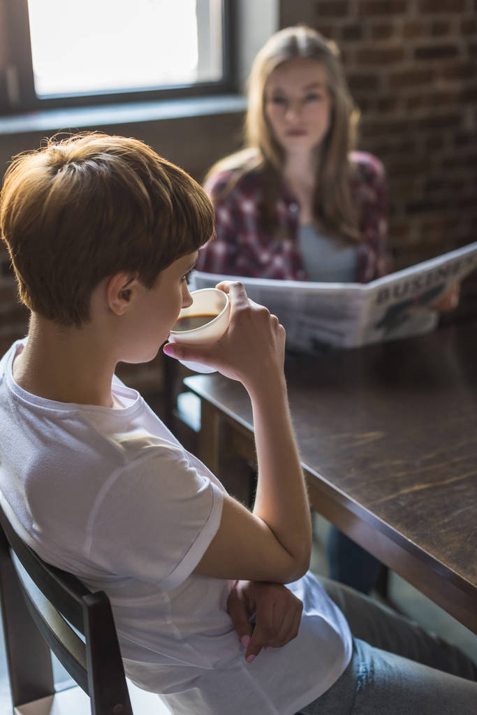 kobiety, czytając gazety i picie kawy na kuchni rano - Zdjęcie, obraz