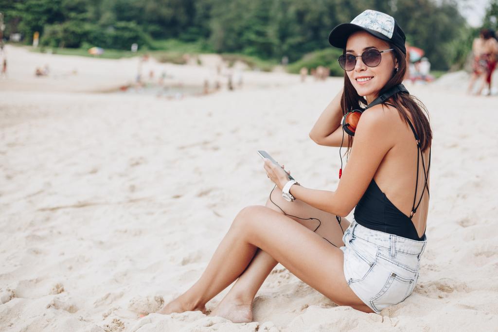 atrakcyjna kobieta smartphone słuchania muzyki za pomocą słuchawek przy plaży - Zdjęcie, obraz