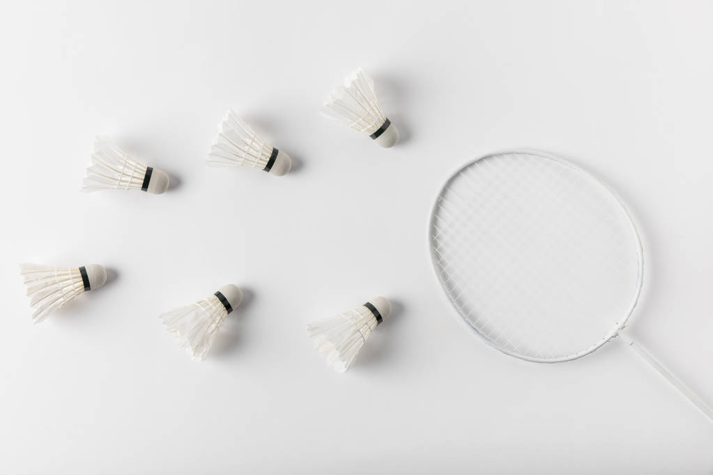 Badminton-Federbälle und Schläger von oben auf weißer Tischplatte - Foto, Bild