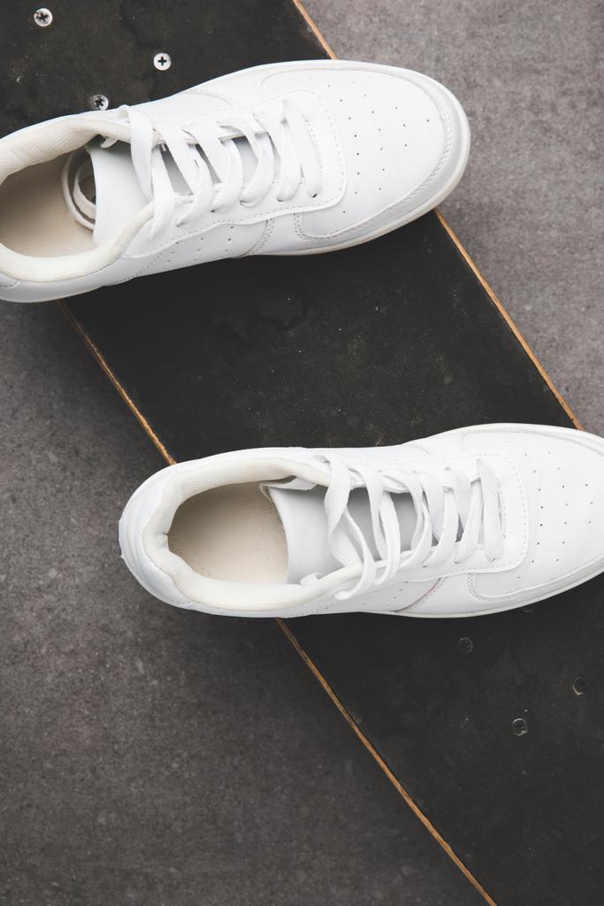 kaykay beton yüzeyi üzerinde beyaz spor ayakkabı Üstten Görünüm - Fotoğraf, Görsel