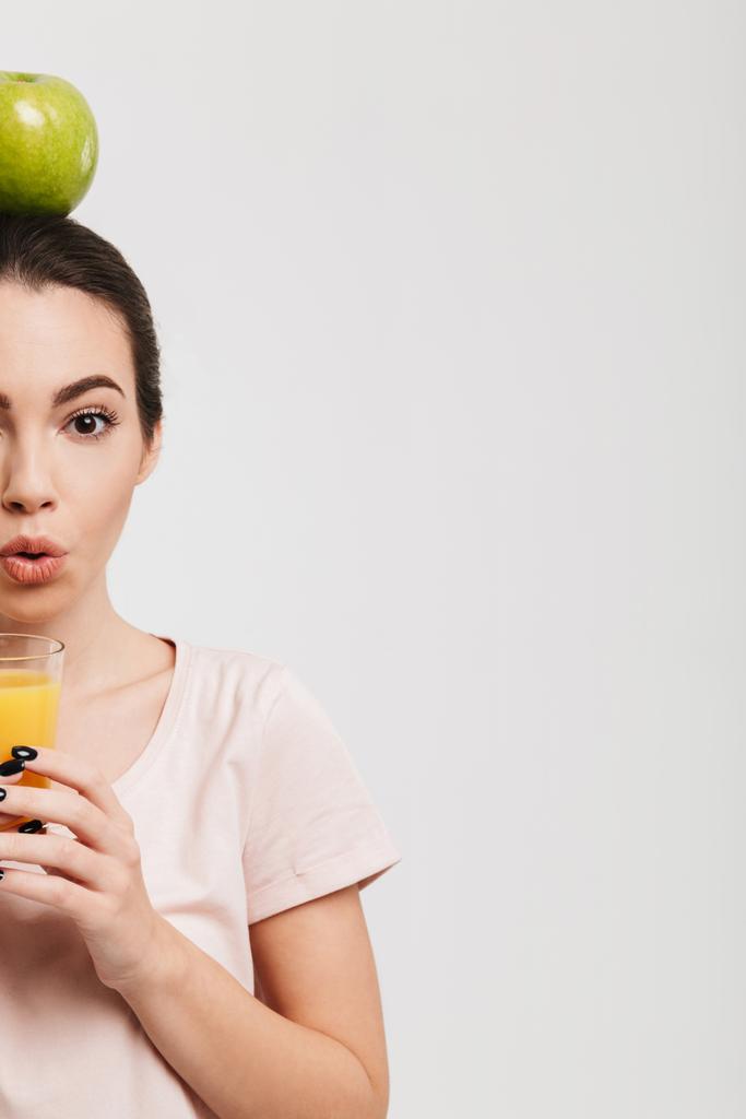 cropped image of girl with apple on head holding glass of juice isolated on white - Photo, Image