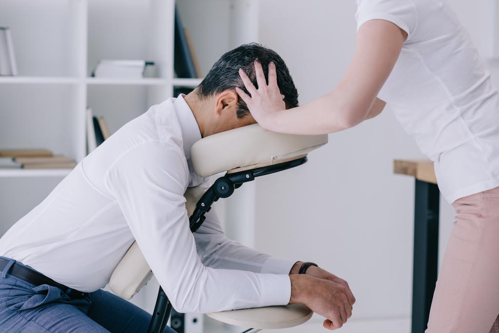 masażystka robi masaż głowy dla biznesmena w pozycji siedzącej - Zdjęcie, obraz