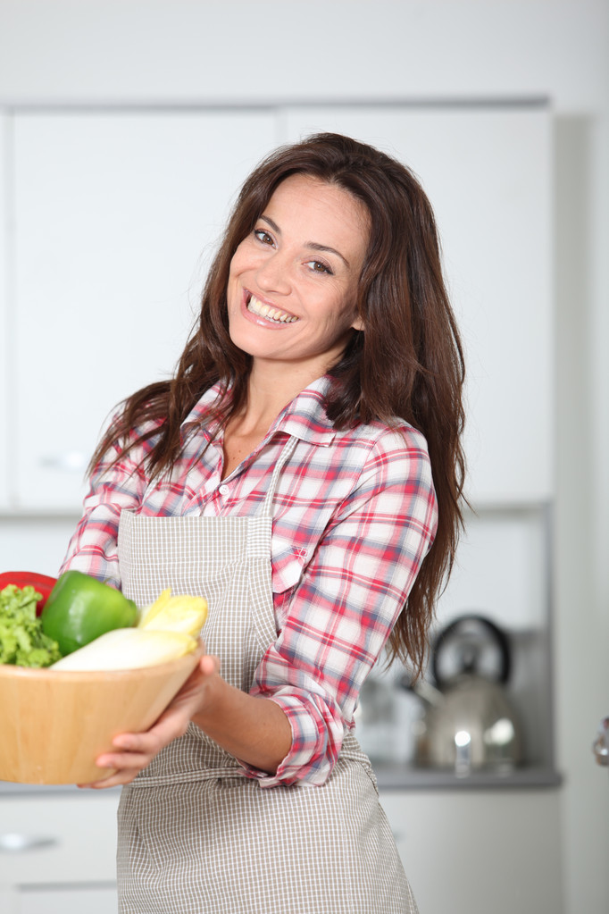 mooie vrouw stading in keuken met schort - Foto, afbeelding
