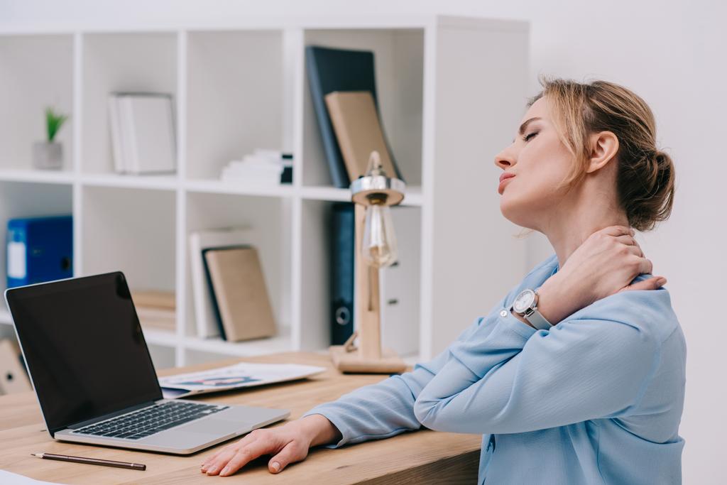 donna d'affari con dolore al collo seduta sul posto di lavoro in ufficio
 - Foto, immagini