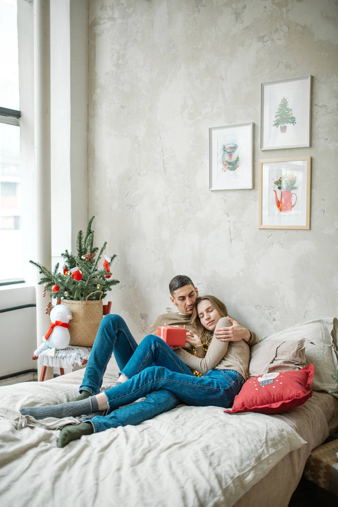 junges kaukasisches Paar legt Geschenke auf dem Bett aus - Foto, Bild