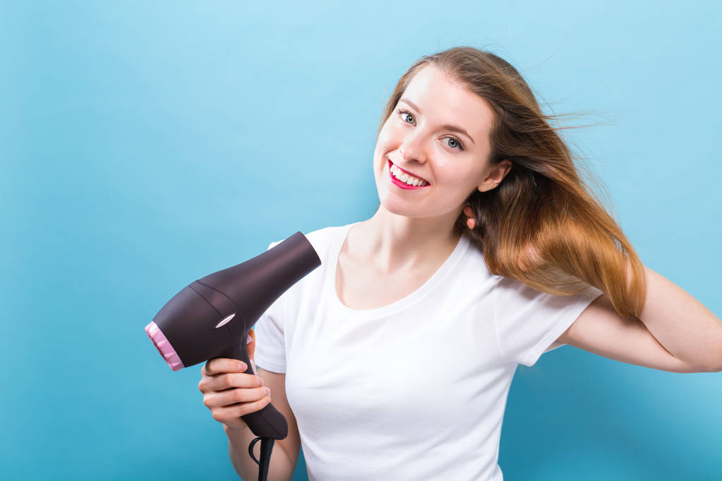 Beautiful woman holding a hairdryer - Photo, Image