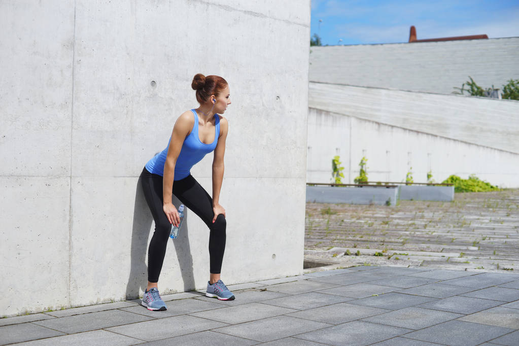 mujer joven, en forma y deportiva que se prepara para el jogging urbano. Fitness, deporte y estilo de vida saludable
. - Foto, imagen