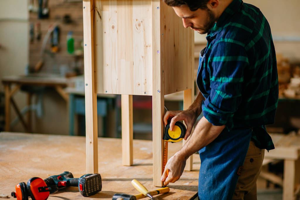Tischler, der in seiner Holz- oder Werkstatt arbeitet - Foto, Bild