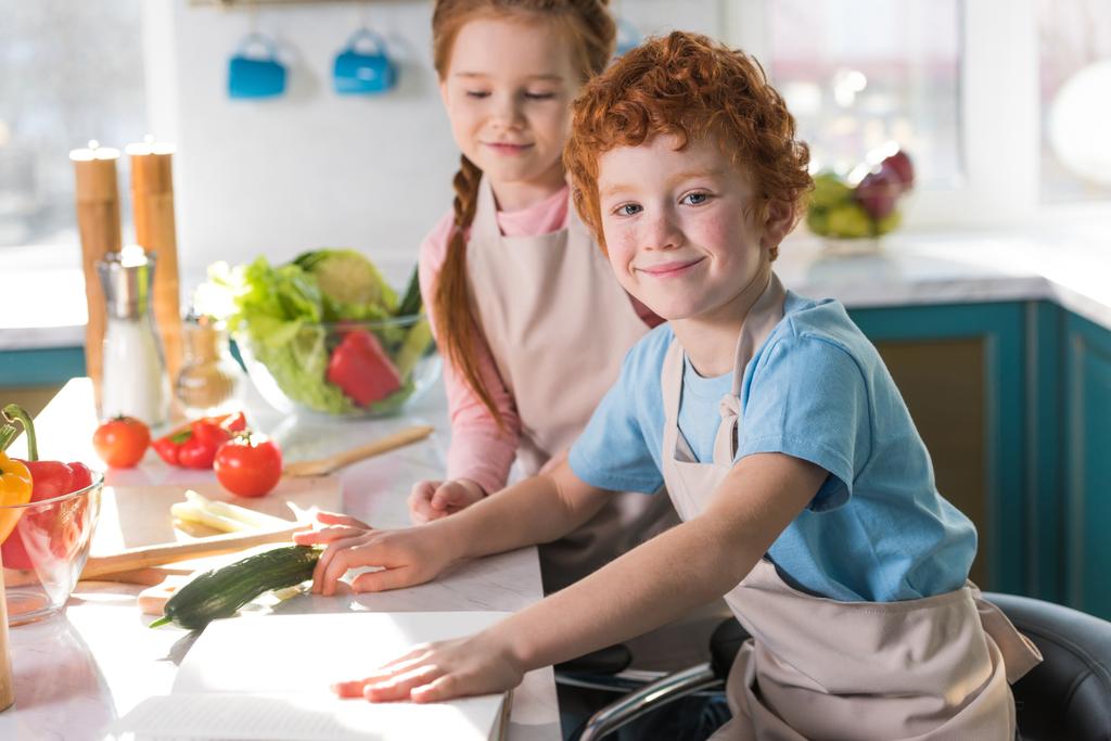 όμορφη ευτυχισμένα παιδιά στις ποδιές μαζί μαγειρική στην κουζίνα - Φωτογραφία, εικόνα
