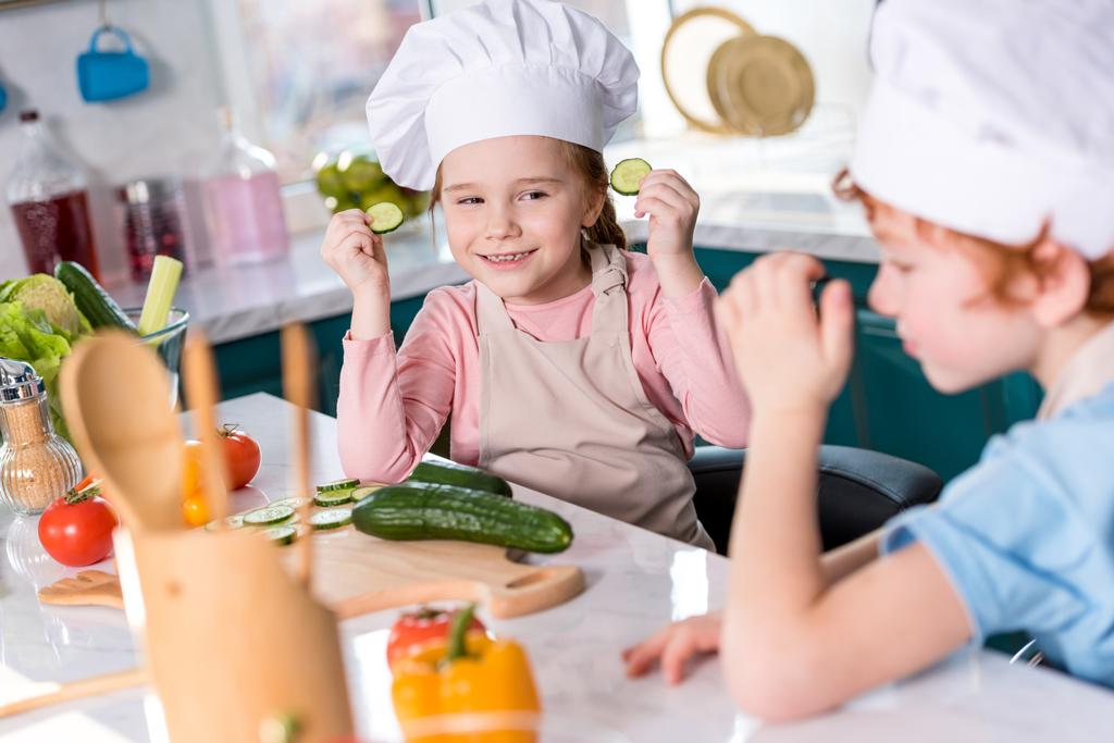 aranyos kis gyermekek szórakozás együtt konyha főzés közben szakács sapka - Fotó, kép