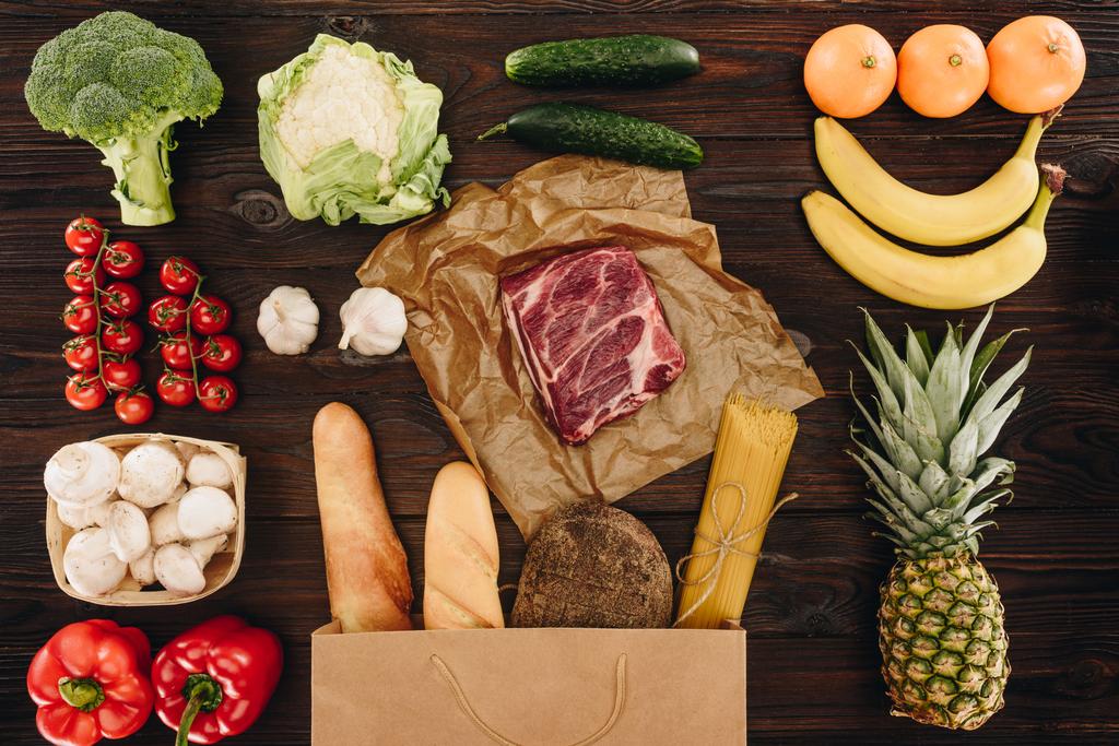 top view of raw meat with vegetables and fruits on wooden table, grocery concept  - Photo, Image