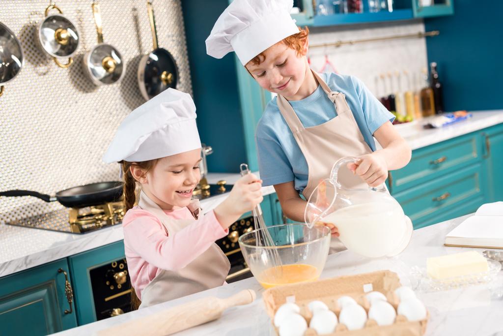 シェフの帽子とエプロン キッチンで一緒に生地の準備で子供の幸せ少し - 写真・画像