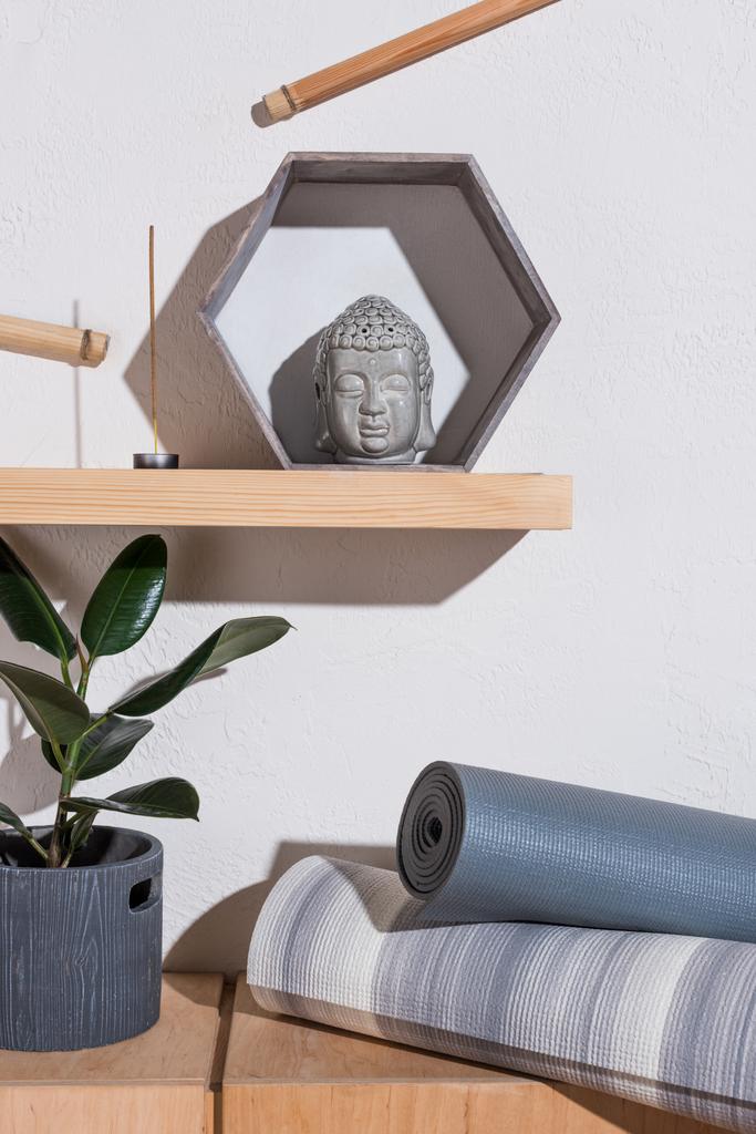 sculpture of buddha head in frame and yoga mats - Photo, Image