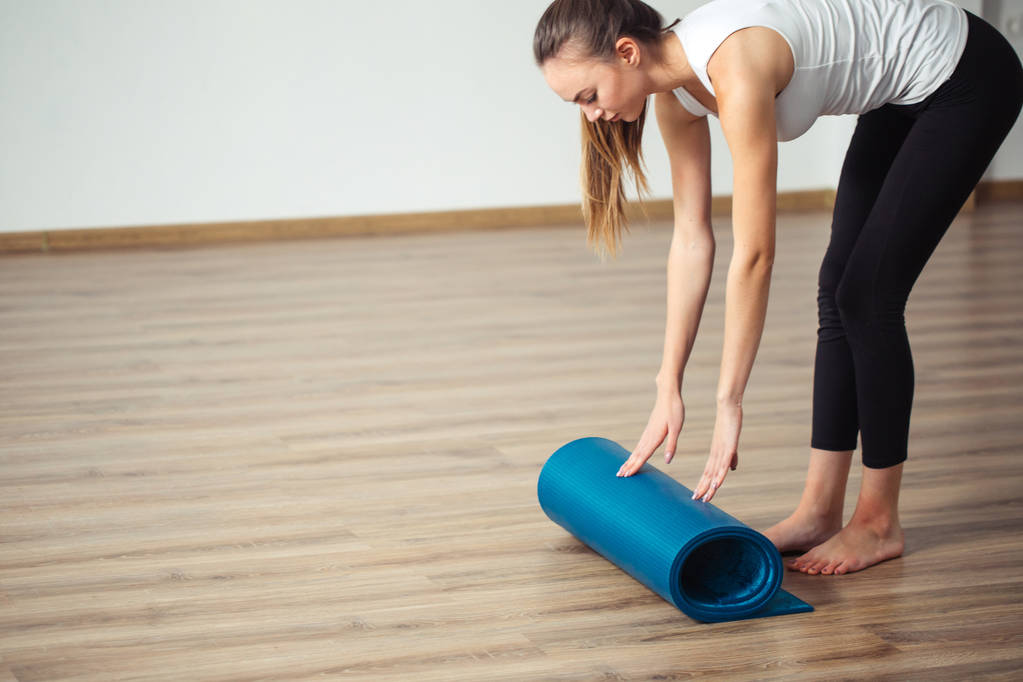 Joogaa harjoittava nainen, joka valmistautuu liikuntaan, liikkuvaan tai liikkuvaan joogamattoon
 - Valokuva, kuva