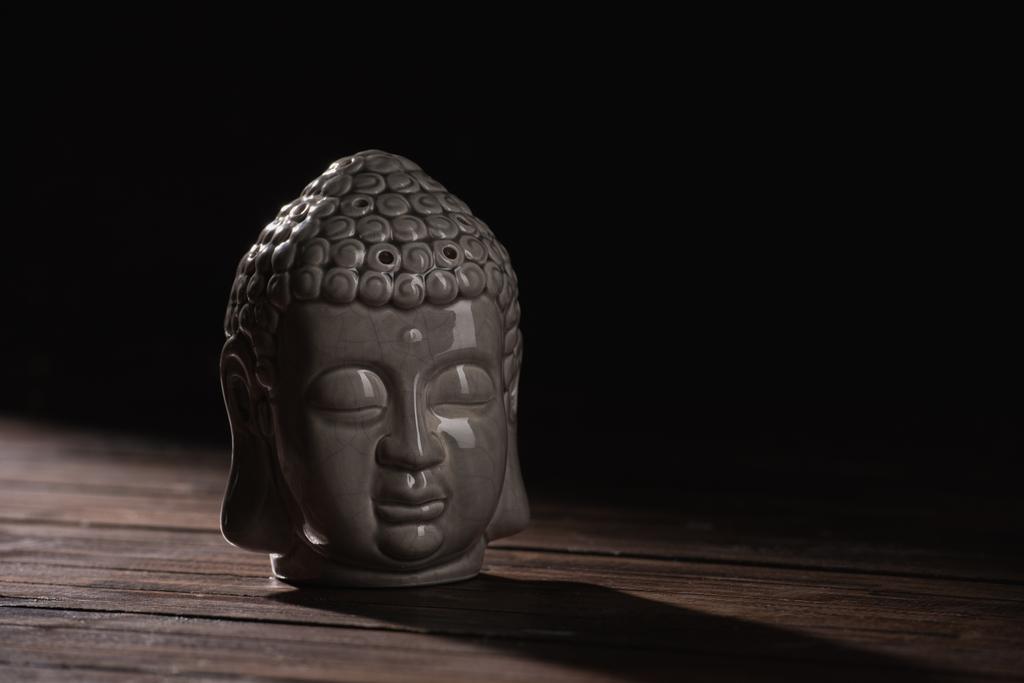 escultura de cabeça de buddha em mesa de madeira
 - Foto, Imagem