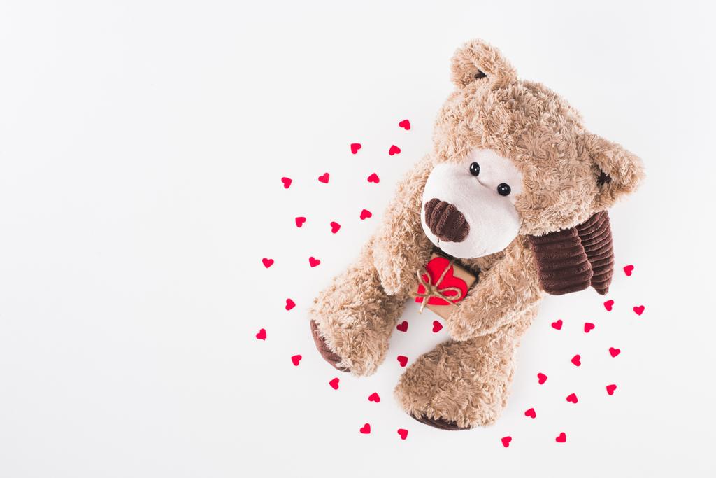 top view of teddy bear with heart shaped gift box and paper hearts isolated on white - Photo, Image