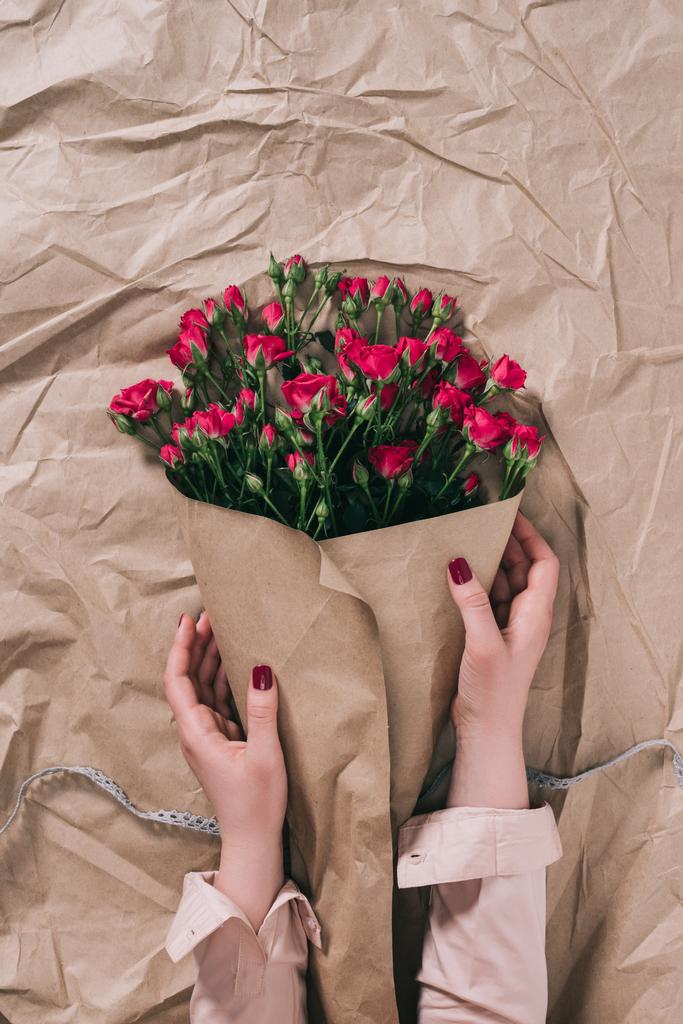 vista parziale delle mani femminili e mazzo di rose in carta artigianale
 - Foto, immagini