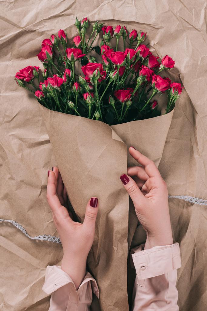 női kéz és a bouquet, rózsa, a papír kézműves részleges megtekintése - Fotó, kép