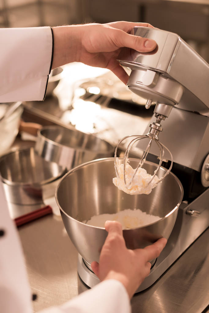 Μερική άποψη του ζαχαροπλάστη κάνοντας κρέμα για επιδόρπιο σε κουζίνα εστιατορίου - Φωτογραφία, εικόνα