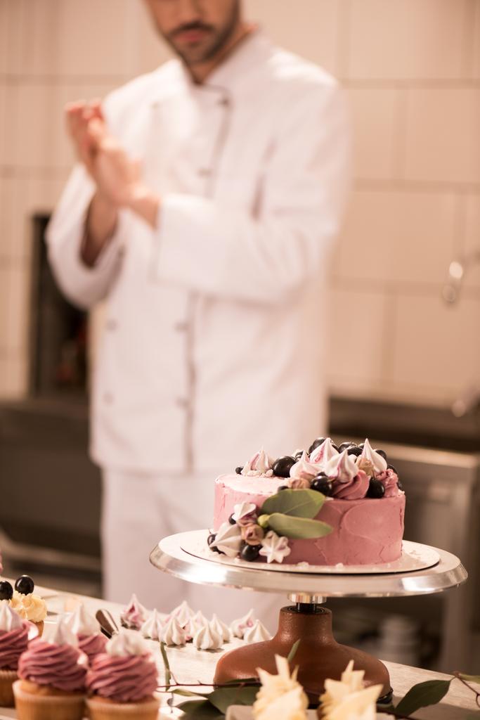 selective focus of cake, cupcakes and confectioner in restaurant kitchen - Photo, Image