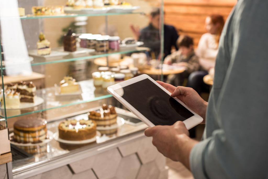 Μερική άποψη του barista χρησιμοποιώντας tablet στην εργασία σε καφετέρια - Φωτογραφία, εικόνα