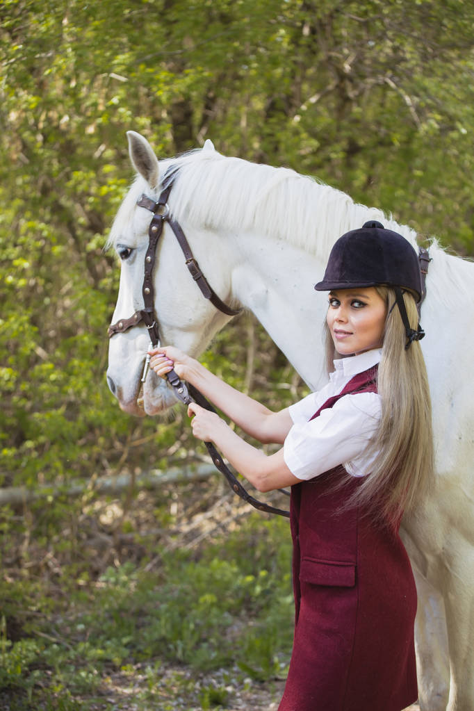 bela menina morena com cabelos longos posando com um cavalo vermelho na floresta
 - Foto, Imagem